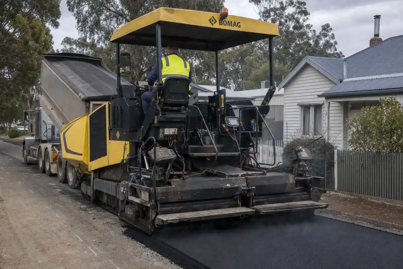 Asphalt paver machine laying hot mix on a residential street in Northern Tasmania